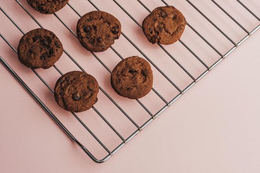 Flat Lay of Homemade Chocolatte Cookies Laid Out on Lattice Lying on Pink Table