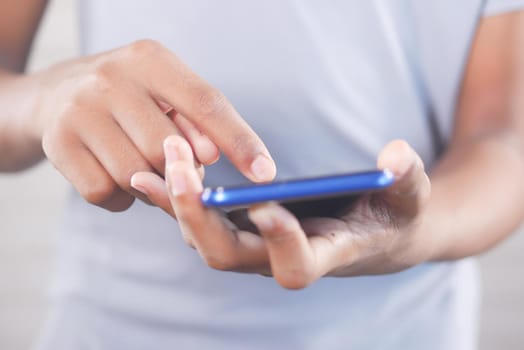 Close up of young man hand using smart phone