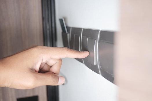 A finger turning on lighting switch