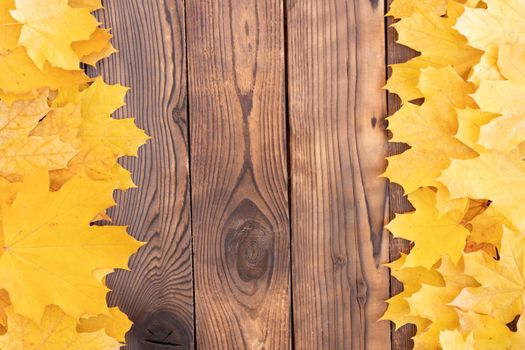 Autumn leaves frame on two left and right side wooden background top view Fall Border yellow and Orange Leaves vintage wood table Copy space. Mock up for your design. Display for product or text