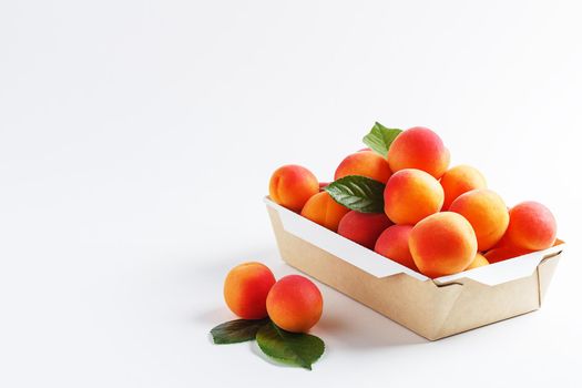 Apricots in paper packaging on a white background. the concept of eco-friendly packaging without plastic. Copy space