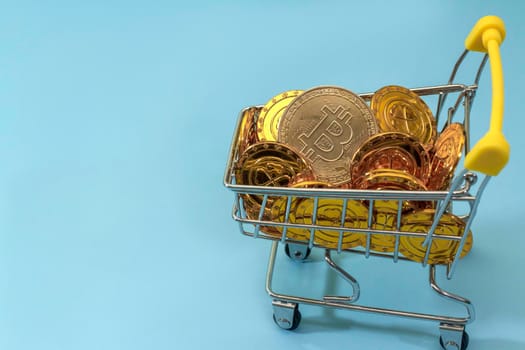 Bitcoin in shopping trolley on blue background, cryptocurrency blockchain buy sell virtual Money investment.