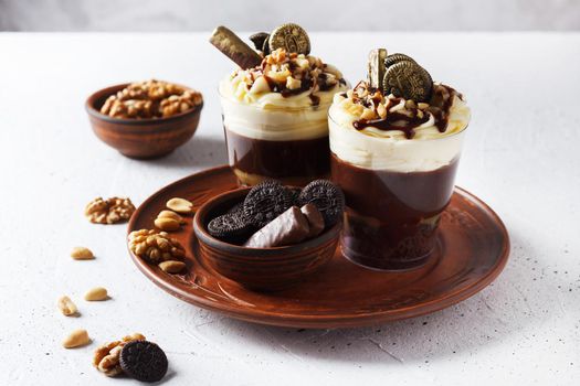 Delicious chocolate trifle or pudding with whipped cream in a glass on a gray background.