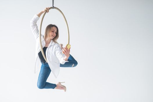 Caucasian woman gymnast on an aerial hoop takes a selfie on a smartphone