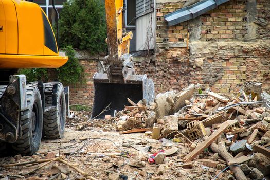 Excavator breaks old house. Freeing up space for the construction of a new building