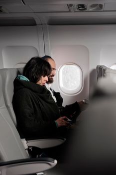 Woman tourist fastening seatbelt before takeoff on airplane flight, buckle up belt to prepare for departure. Flying in economy class and travelling by plane to leave on vacation journey.