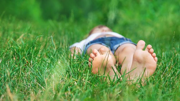 Children's feet on the green grass in the park. Selective focus. nature.