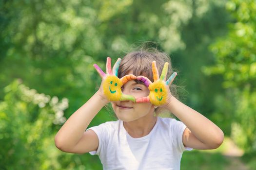 Child hands in paints a smile. Selective focus.
