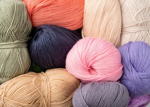 Knitting needles, colorful threads. Selection of pastel colored yarn wool on shopfront. Knitting background, a lot of balls. Knitting yarn for handmade winter clothes