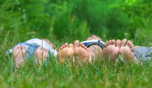 Children's feet on the green grass in the park. Selective focus. nature.