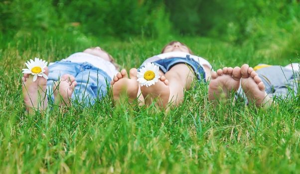 Children's feet with chamomile on green grass. Selective focus. nature.