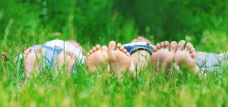 Children's feet on the green grass in the park. Selective focus. nature.