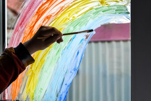 hand painting rainbow on a window, stay home during quarantine, Image of kids leisure at home, Chase the rainbow flashmob