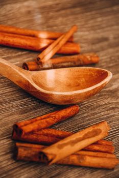 cinnamon sticks on the table with wooden spoon , beautiful christmas background with spices, copy space, wood background
