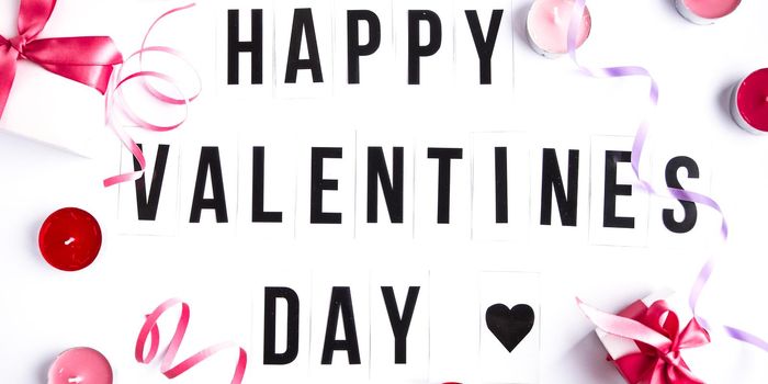 Happy valentines day text on white table background, heart, holiday concept, greeting card, Present boxes with pink ribbon, candles