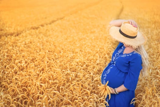 Pregnant woman in a wheat field. Selective focus. nature.