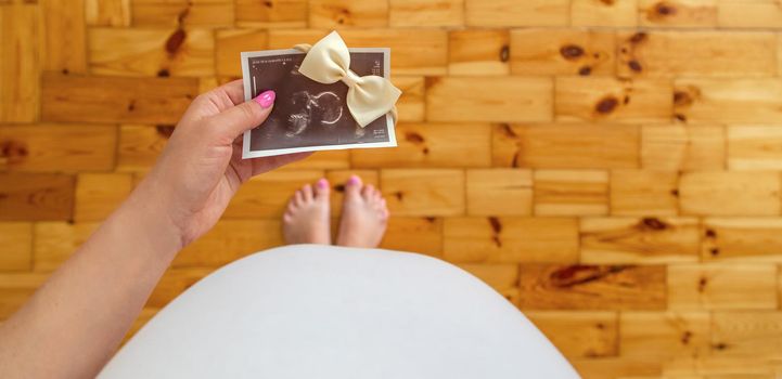 Pregnant woman with girl ultrasound picture. Selective focus. people.