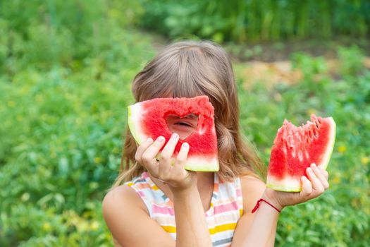 A child on a picnic eats a watermelon. Selective focus. Food.