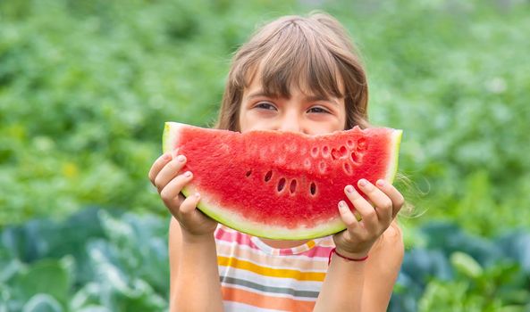 A child on a picnic eats a watermelon. Selective focus.