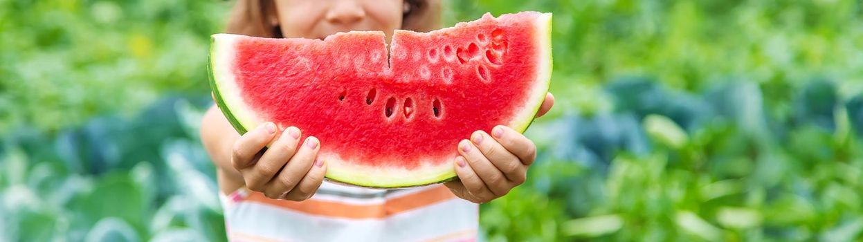 A child on a picnic eats a watermelon. Selective focus. food.