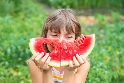 A child on a picnic eats a watermelon. Selective focus. Food.