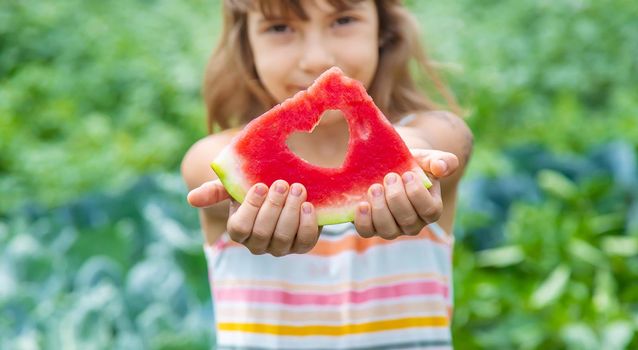 A child on a picnic eats a watermelon. Selective focus. Food.