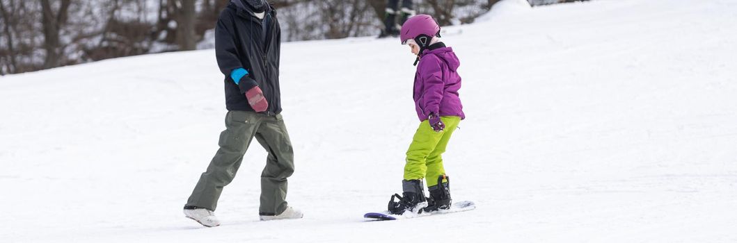 Ski Resort Father Teaching Little Daughter Snowboarding.