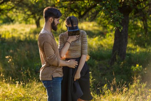 couple in nature, girl in virtual reality glasses close-up