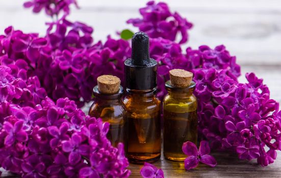 Lilac essential oil in a small bottle. Selective focus. Nature.
