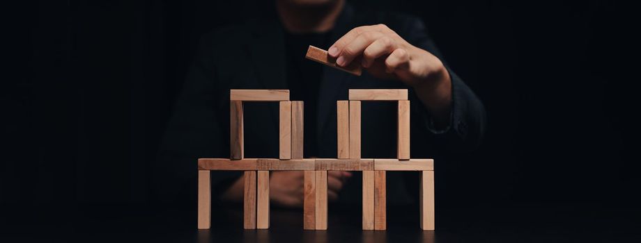 Young businessman with wooden block. Business strategy and development concept.