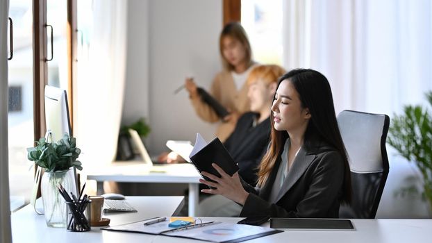 Thoughtful businesswoman reading information on her notebook.