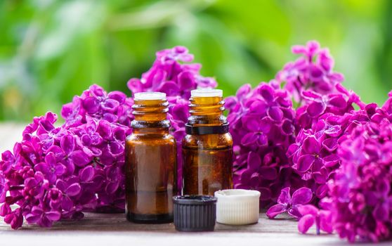 Lilac essential oil in a small bottle. Selective focus. Nature.