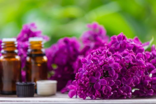 Lilac essential oil in a small bottle. Selective focus. Nature.