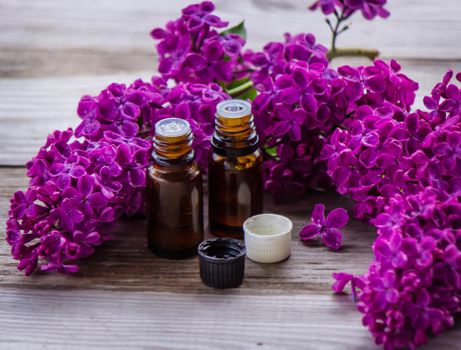 Lilac essential oil in a small bottle. Selective focus. Nature.