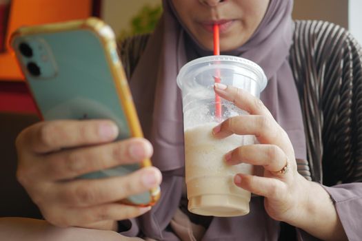 young women drinking banana milk shake at cafe .