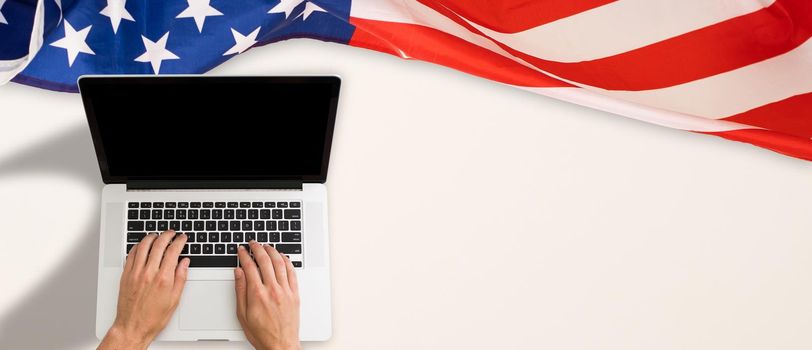 Workplace with modern laptop, letters and USA flag near light wall. High quality photo