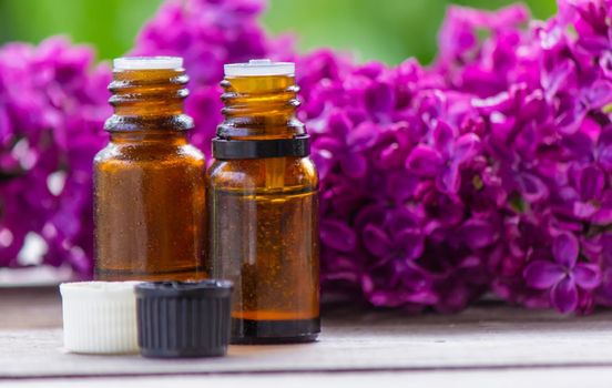 Lilac essential oil in a small bottle. Selective focus. Nature.