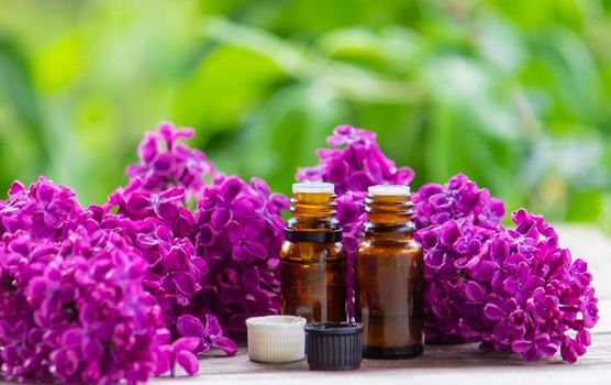Lilac essential oil in a small bottle. Selective focus. Nature.
