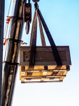 The crane carrying a wooden box of the radioactivity instrument holder transportation wooden box