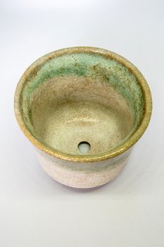 The ceramic cup has been adapted for planting small pot plants