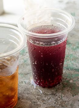 Soft drink and ice in the disposable plastic glasses