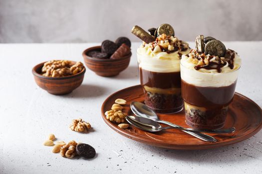 Delicious chocolate trifle or pudding with whipped cream in a glass on a gray background.