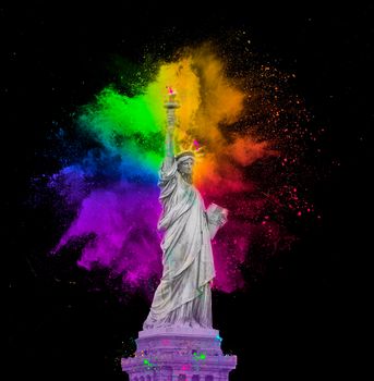 Statue of Liberty with colorful rainbow holi paint powder explosion isolated on black