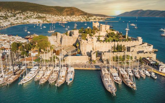 Sunset in yacht port at Castle.  Yachting sunset scene. Yachts in sunset bay. Castle of St. Peter Bodrum Marina, sailing boats and yachts in Bodrum, Turkey