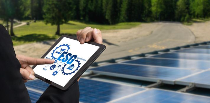 Green business transformation for environment saving and ESG business concept. Businessman using tablet to set corporate goal toward environmental friendly management and alternative clean energy use.