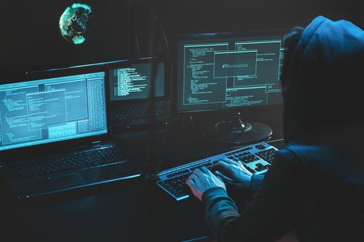 Cyber criminal hacking system at monitors, hacker attack web servers in dark room at computer with monitors sending virus using email vulneraility. Internet crime, hacking and malware concept. Download image