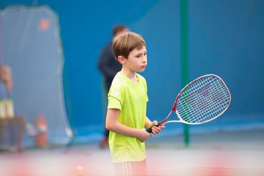 Little boy with a tennis racket. The child plays tennis.