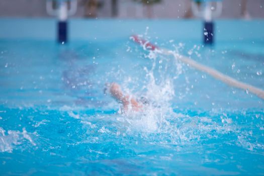 An athlete is swimming in the sports pool.