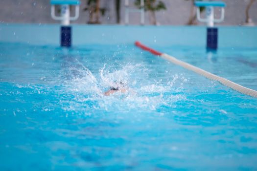 An athlete is swimming in the sports pool.