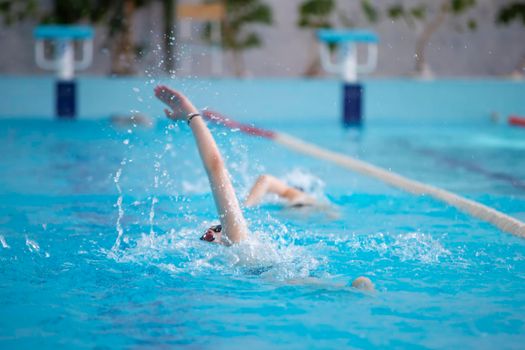 An athlete is swimming in the sports pool.